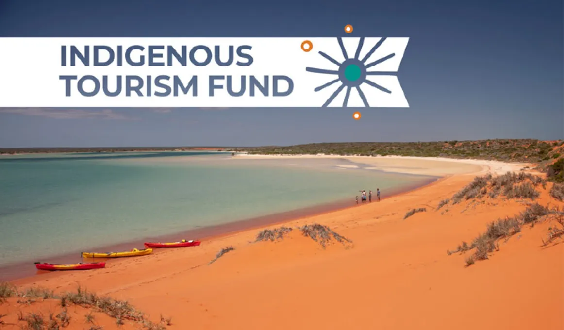 A picture of a sandy beach with clear blue water. Above  the beach, the words 'Indigenous Tourism Fund' appear.