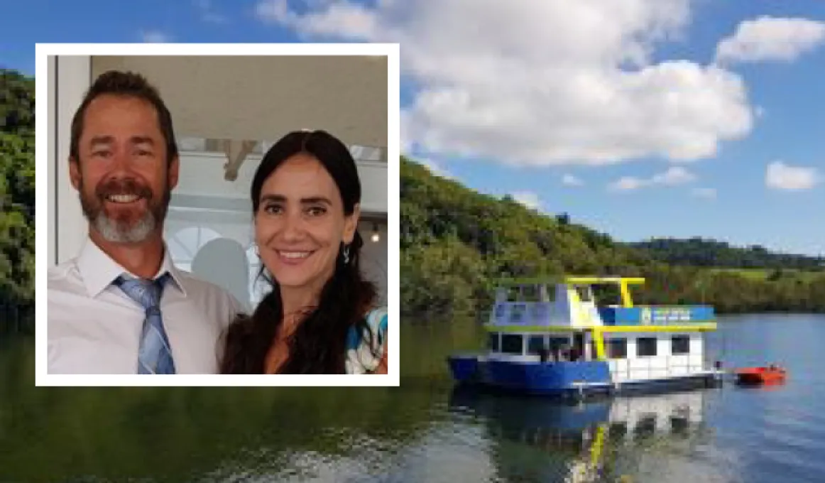 At left is a man and woman standing in a room. They wear semi-formal wear and at right, a houseboat floats on a river. In the background is the tree covered bank and a blue and cloudy sky.