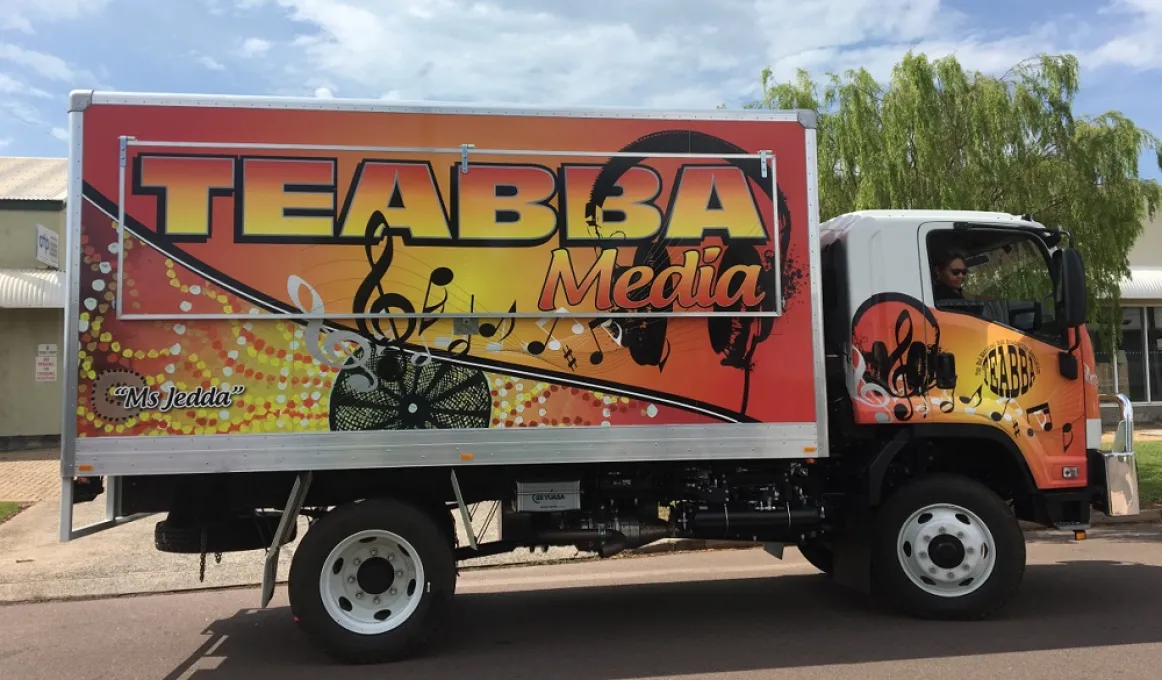 A large truck belonging to TEABBA Media is covered with Indigenous dot patterns.