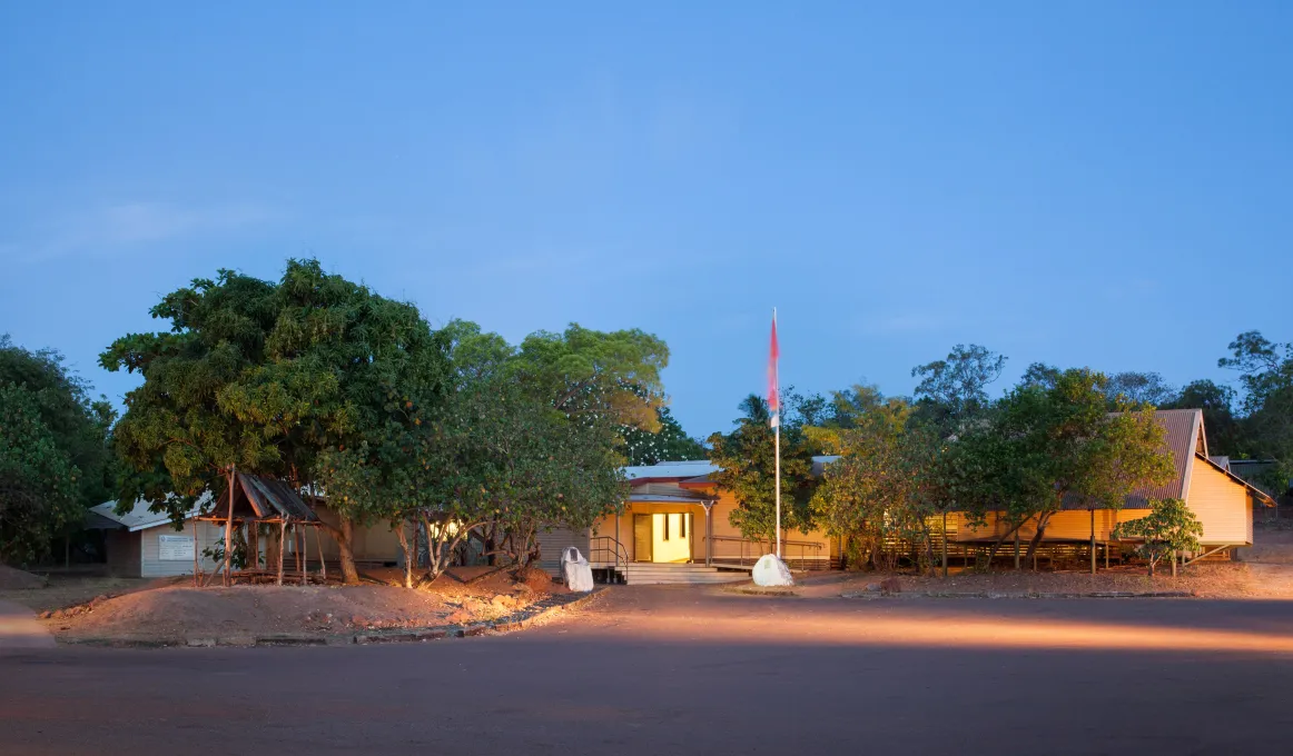 Buku-Larrnggay Mulka Centre sitting among trees with flag in front.