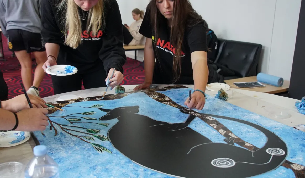 Participants at the NASCA NAIDOC Youth Conference painting together in a traditional style.