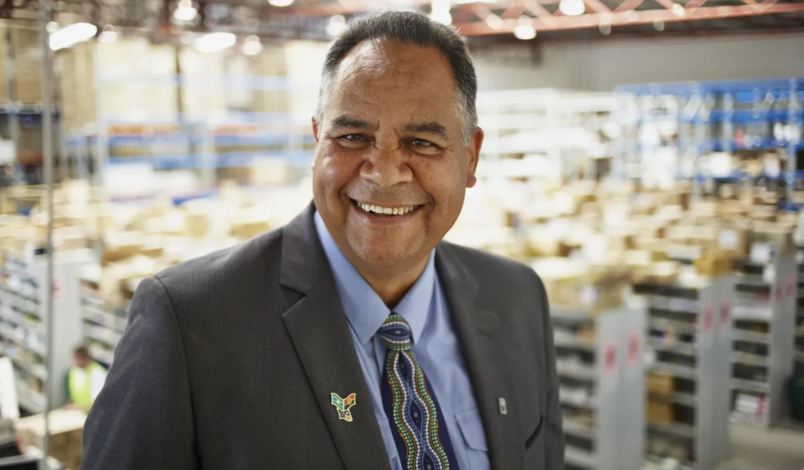 Indigenous man in warehouse wearing suit.