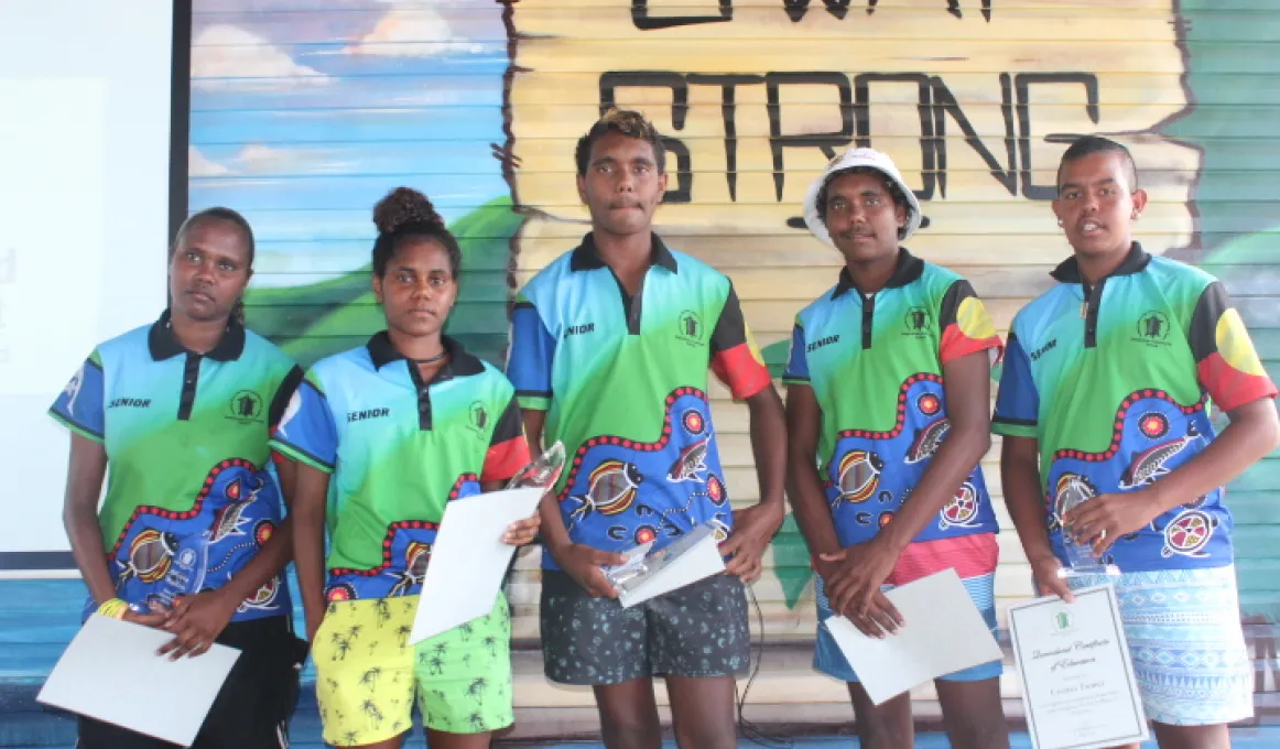 Photo of 5 students in front of a mural on Palm Island