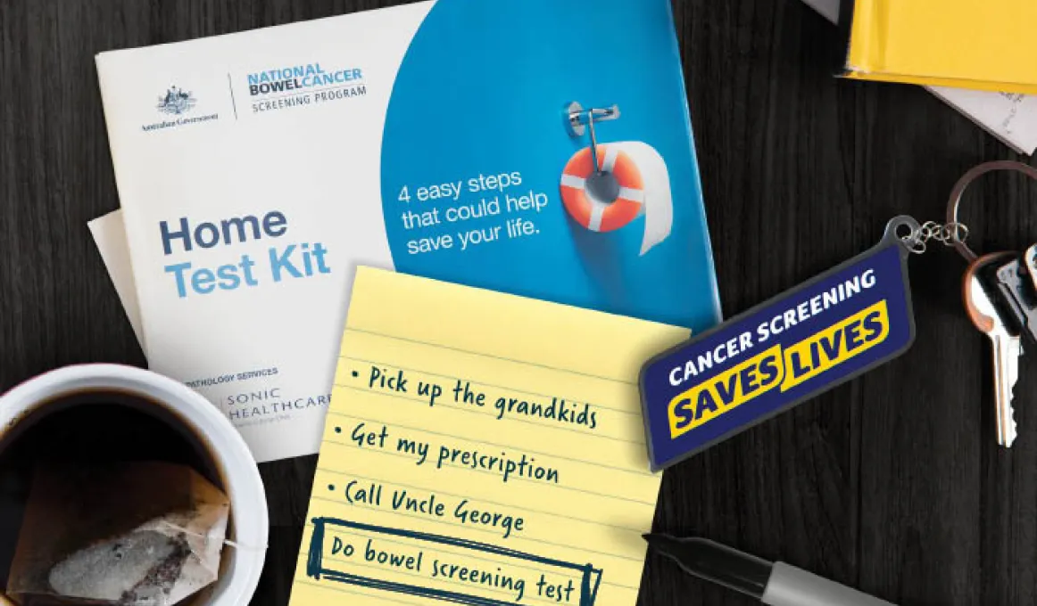 image of multiple items on a dark background. Items include key ring with words cander screening saves lives and package with words: home test kit.