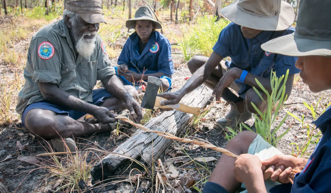 Crocodile Islands Ranger and Cultural Advisor George Milaypuma showing Junior Rangers how to make bush string.