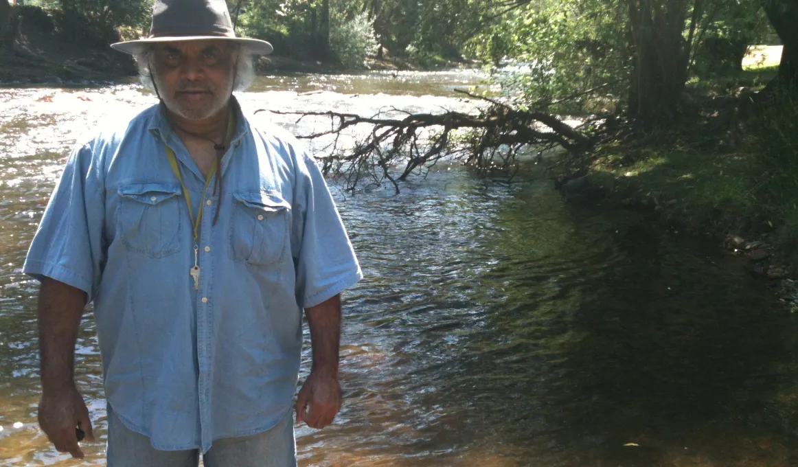 Dhudhuroa Elder Gary Murray standing in the Ovens River in Dhudhuroa Country