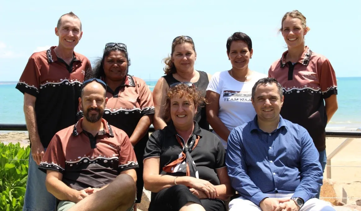 A group photograph of eight members of the North Australian Aboriginal Justice Agency (NAAJA).