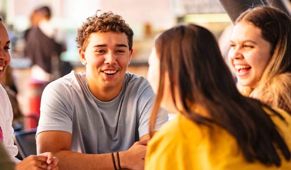 Four people sitting around a table in conversation.