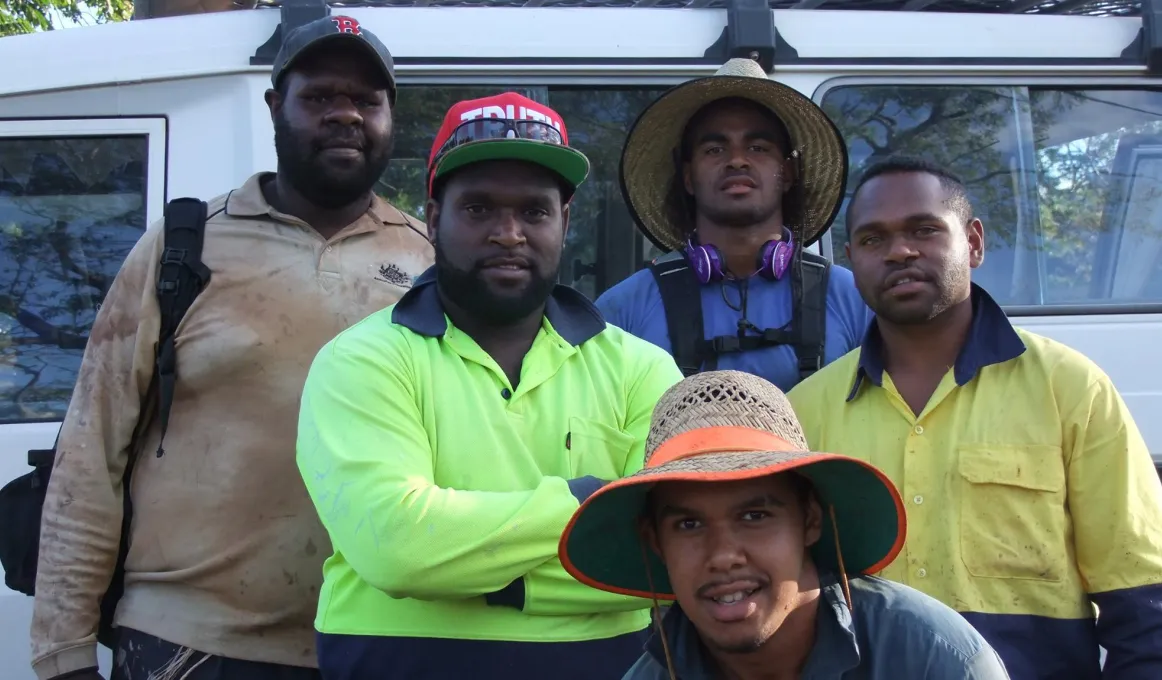 Five Torres Strait Islander young men dressed in work clothing standing in front of a van.