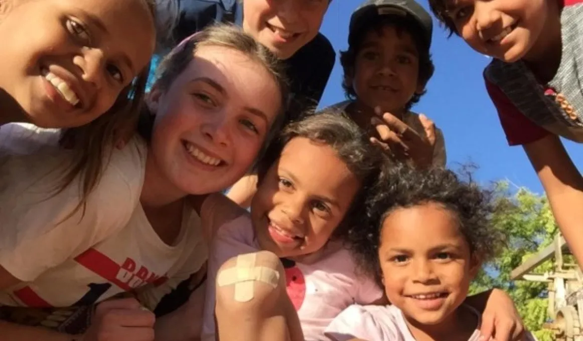 Several children grouped together look down at the camera from closeup positions.