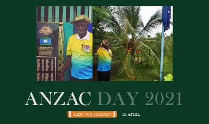 At right, an elderly man wearing a yellow and blue shirt and kaki hat salutes a blue flag on a flagpole. At left, the same man stands next to a memorial with names engraved on it.