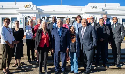 A group of 15 people stand together. Minister Ken Wyatt is in the cente of the image.