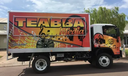 A large truck belonging to TEABBA Media is covered with Indigenous dot patterns.