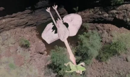 An animated figure of a large bird in flight holding a frog in its mouth. Underneath them is a water hole, an escarpment, rocks and trees.