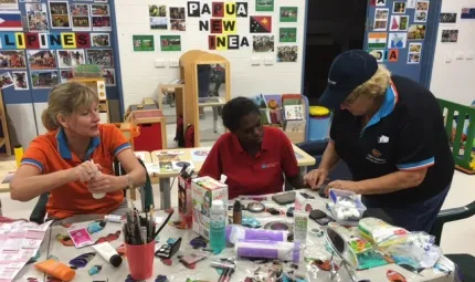 Apunipima Cape York Health Council Maternal and Child Health midwife Lisa Smith (left) and diabetes nurse educator Cath Dowey with Tammy Conrad (centre) discuss healthy eating, over some art and craft activities.