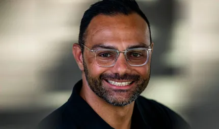 Head and shoulders shot of an Indigenous man with a beard and wearing glasses.