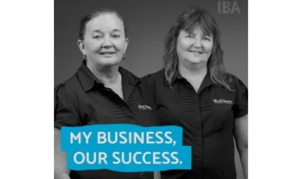 Two women in dark tops stand shoulder to shoulder facing the camera. At the base of the image on a blue background is text: My business, our success.