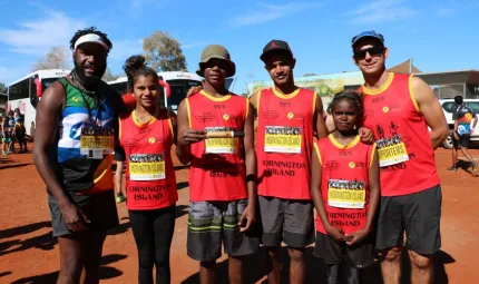 Six young athletes stand in the red dirt of central Australia.