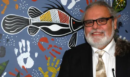 Founder & CEO of Nallawilli Technology, Roderick McLeod, stands in front of an indigenous painting