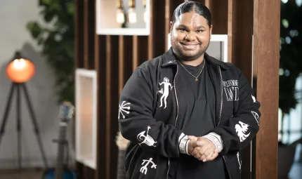 Australian Idol winner Royston Sagigi-Baira, a Torres Strait Islander man, wearing a black t-shirt and black jacket. He is smiling at the camera.