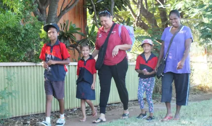 Five people walking along a footpath.