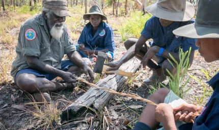 Crocodile Islands Ranger and Cultural Advisor George Milaypuma showing Junior Rangers how to make bush string.