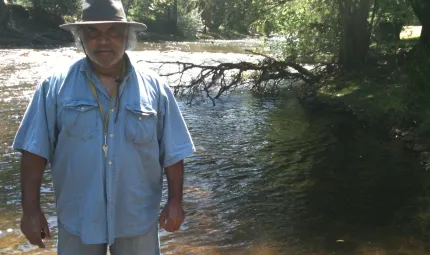 Dhudhuroa Elder Gary Murray standing in the Ovens River in Dhudhuroa Country