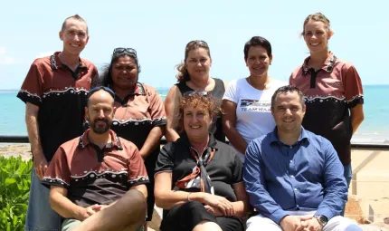 A group photograph of eight members of the North Australian Aboriginal Justice Agency (NAAJA).