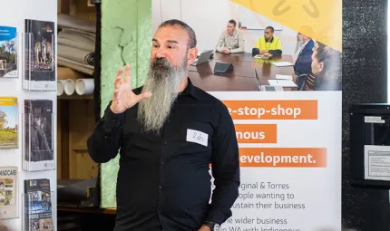 Wirra Hub Business Coach, Rob Barton speaking in front of a group of people with a Wirra Hub banner behind him.