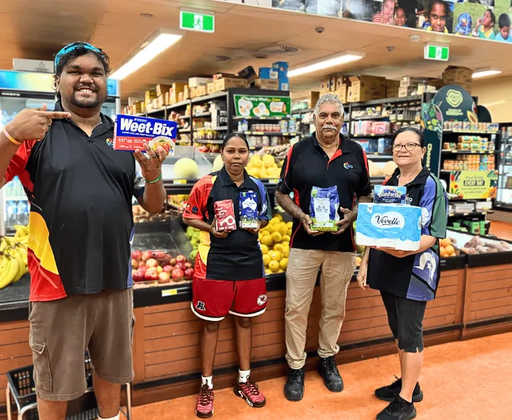 People hold common items up in a supermarket