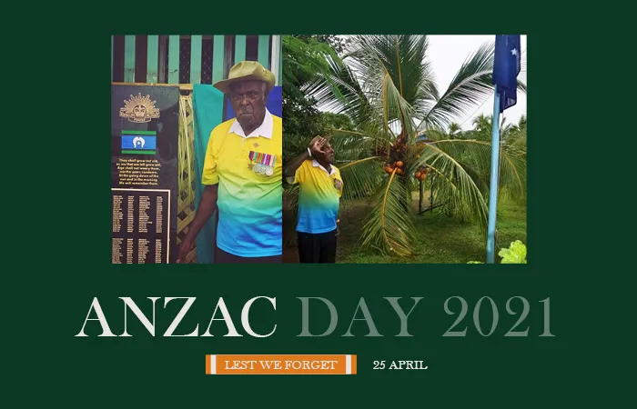 At right, an elderly man wearing a yellow and blue shirt and kaki hat salutes a blue flag on a flagpole. At left, the same man stands next to a memorial with names engraved on it.