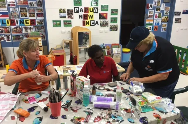 Apunipima Cape York Health Council Maternal and Child Health midwife Lisa Smith (left) and diabetes nurse educator Cath Dowey with Tammy Conrad (centre) discuss healthy eating, over some art and craft activities.