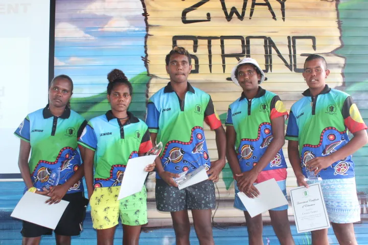 Photo of 5 students in front of a mural on Palm Island