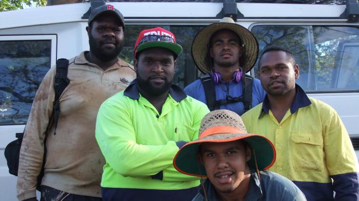 Five Torres Strait Islander young men dressed in work clothing standing in front of a van.