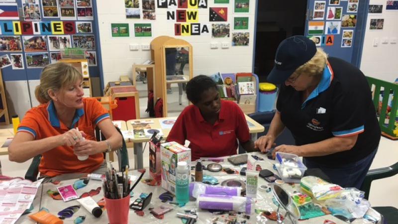 Apunipima Cape York Health Council Maternal and Child Health midwife Lisa Smith (left) and diabetes nurse educator Cath Dowey with Tammy Conrad (centre) discuss healthy eating, over some art and craft activities.