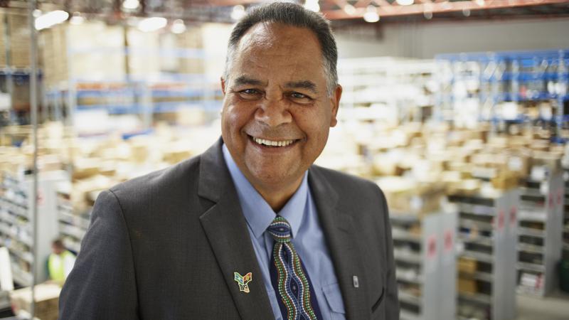 Indigenous man in warehouse wearing suit.