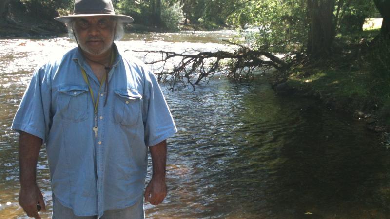 Dhudhuroa Elder Gary Murray standing in the Ovens River in Dhudhuroa Country