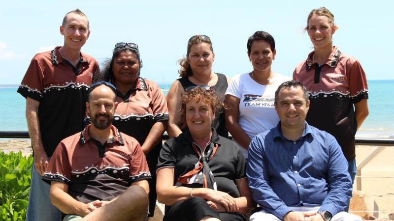 A group photograph of eight members of the North Australian Aboriginal Justice Agency (NAAJA).