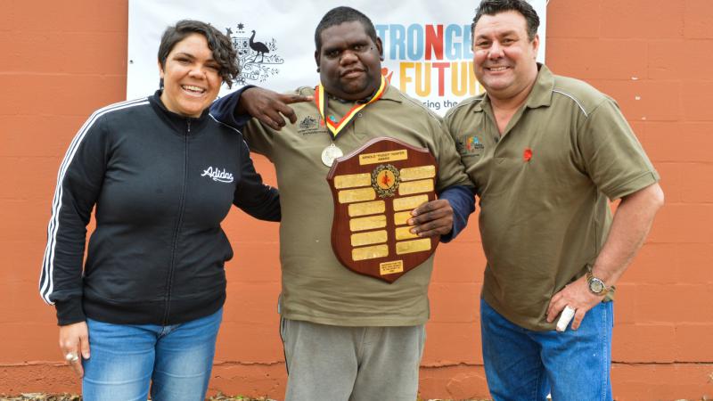 Jameson (centre) with his volunteer award at the Stronger Futures Alice 3on3. Pictured with role model Jacinta Price and Vibe Australia Managing Director, Gavin Jones.