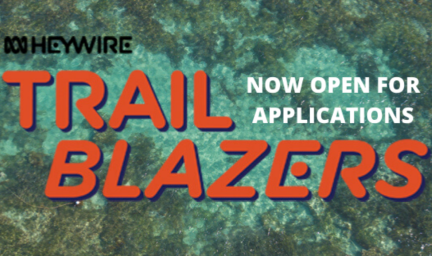 On a green and blue background, the words "Trailblazers" appears in orange text. Above, it says the words "applications now open" in white text and the words Heywire in black text.