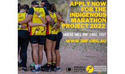 A group of people are arm in arm having formed a circle. They are dressed in yellow tops and dark shorts of running pants. They stand on sandy soil. At right is the text: Apply now for the Indigenous Marathon project 2022. Where will IMP take you?